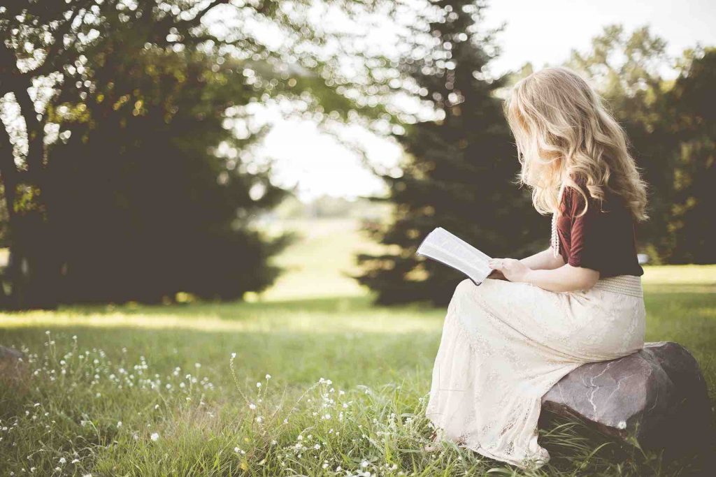 Picture of a healthy woman reading outside
