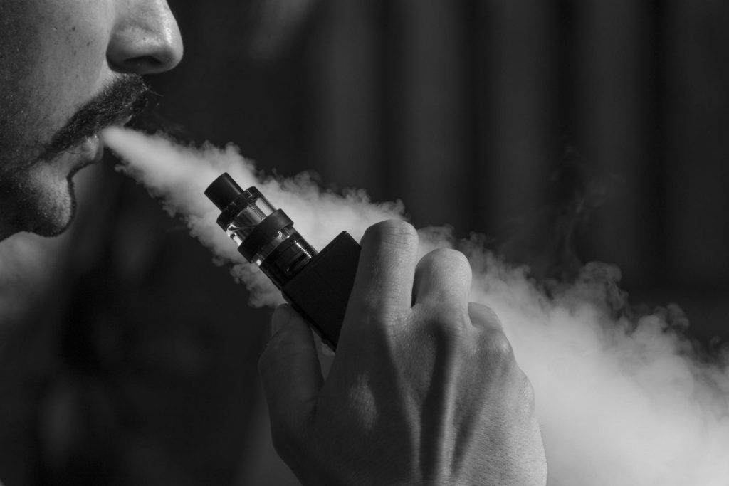 Black and white photo of a man vaping